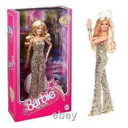 Poupée de collection Barbie Le Film, Margot Robbie en combinaison disco dorée à la main.